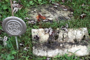 A headstone flush with the ground, no letters visible