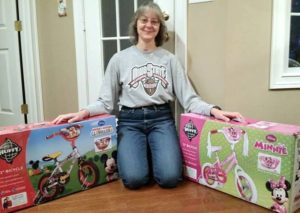 Photo of Shari with two boxed bikes. Photo by Bike Lady