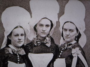 three women in tall white hats and black dresses